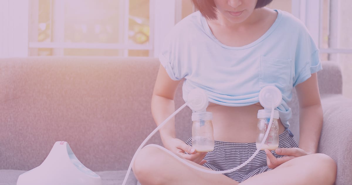 woman sits on couch with breast pump attached
